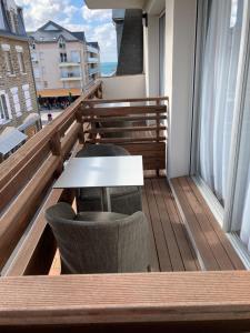 a balcony with a table and chairs on a balcony at Hotel Georges in Pléneuf-Val-André