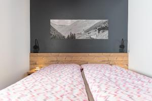 a bedroom with a bed with a picture on the wall at Appartamenti Roby - Appartamenti Abar in Livigno