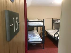 a room with three bunk beds and a door at Derwentwater Independent Hostel in Keswick