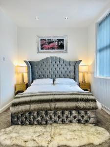 um quarto com uma cama grande e uma cabeceira de cama abobadada em Monopoly Holiday Home em Blackpool