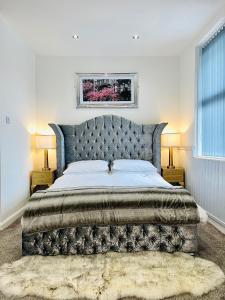 a bedroom with a large bed with a tufted headboard at Monopoly Holiday Home in Blackpool