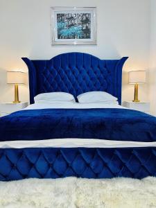 a blue bed in a bedroom with two lamps at Monopoly Holiday Home in Blackpool