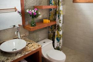 a bathroom with a white toilet and a sink at Chez Manany Galapagos Ecolodge in Puerto Villamil