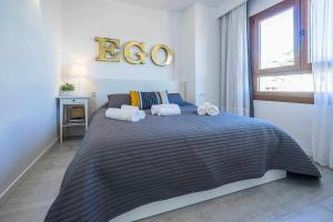 een slaapkamer met een groot bed en handdoeken bij Apartamento Rambla 36 in Alicante
