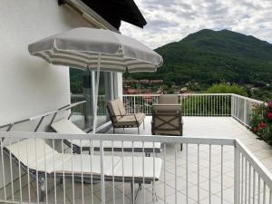 un balcone con 2 sedie e un ombrellone di Bellavista a Brezzo