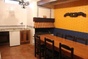 eine Küche mit einem Holztisch, Stühlen und einem Herd in der Unterkunft SagastiEnea Villa con Piscina y Tenis en la Rioja in Samaniego