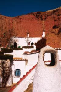 un bâtiment blanc avec une montagne en arrière-plan dans l'établissement Cuevas Pedro Antonio de Alarcon, à Guadix
