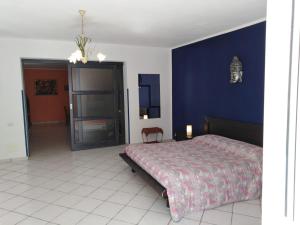 Appartamento Asia في ليباري: غرفة نوم بسرير وجدار ازرق