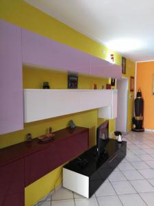 een woonkamer met kleurrijke muren en een tv bij Appartamento Asia in Lipari