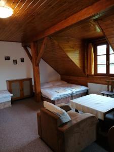 a attic room with two beds and a couch at Jonášův Mlýn in Zhoř u Mladé Vožice