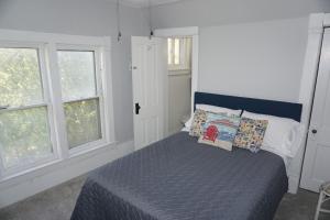 a bedroom with a bed and two windows at Charlevoix House - The Northside in Charlevoix
