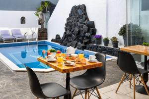 a table and chairs in front of a pool at Plastiras Rooms in Fira