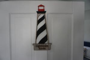 a black and white striped tie with a lighthouse sign on a door at Charlevoix House - The Northside in Charlevoix