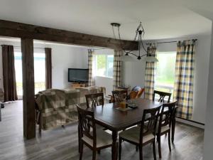 a dining room and living room with a table and chairs at La Grange sur le Lac App A et B in Saint Romain