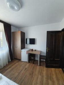 a small room with a table and a refrigerator at Daiana Residence Turda in Turda