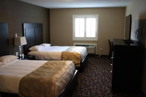 una camera d'albergo con due letti e una finestra di CHINOOK INN a Rocky Mountain House