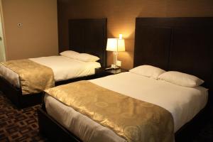 a hotel room with two beds and a lamp at CHINOOK INN in Rocky Mountain House +4 photos