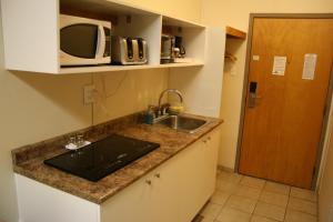 a kitchen with a sink and a microwave at CHINOOK INN in Rocky Mountain House