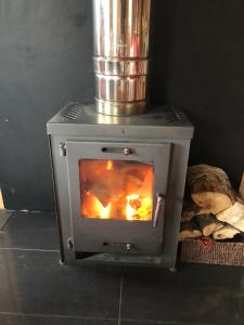 una estufa con fuego en su interior en Loch Lomond Lodge, en Rowardennan