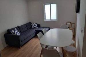 ein Wohnzimmer mit einem blauen Sofa und einem weißen Tisch in der Unterkunft Casa de São Roque Açores in Ponta Delgada