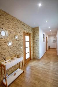 a living room with a stone wall and a table at Apartamento Martinez Padrón in Padrón