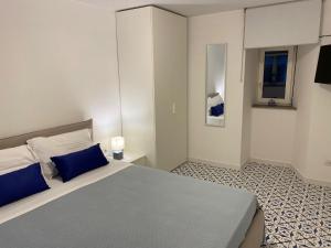 een slaapkamer met een groot bed met blauwe kussens bij William Apartment Sorrento in Sorrento