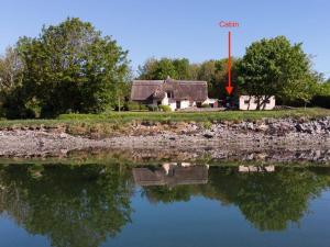 uma casa ao lado de um lago com uma seta vermelha a rotular grãos em The Cosy Cabin by the shore em Galway