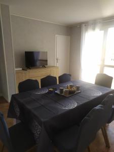 a dining room with a table with chairs and a television at appartement 8 couchages 3 chambres in Sens