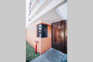 a hallway with a black door and a brick wall at N1A1 - New, Nice, for Long and Short Stay in Asuncion