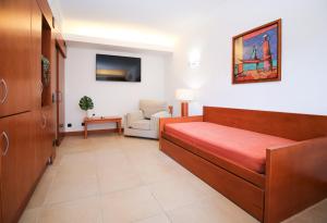 a hospital room with a bed and a chair at Sea Gardens - Alvaflor - Vilamoura in Vilamoura
