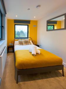 a yellow bedroom with a bed with towels on it at Pres Pier Apartment - Bournemouth in Bournemouth