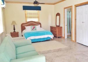a living room with a bed and a couch at Exuma Beach Point in Rolleville