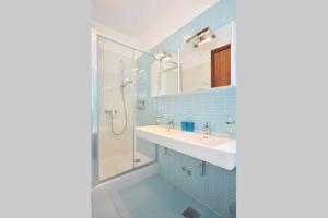 a blue bathroom with a sink and a shower at Wohnung mit 2 Schlafzimmer in der Villa Miravala in Milna