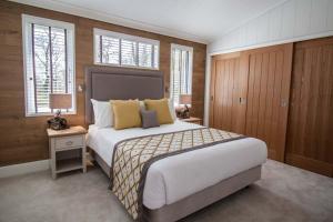 a bedroom with a large bed and two windows at High Oaks Grange - Contemporary Lodges in Pickering