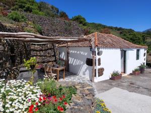 a small white building with flowers in front of it at VV Casa Bastina "by henrypole home" in Mazo