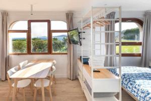 a bedroom with a bunk bed and a table and a desk at LUR Apartaments Getaria in Getaria