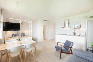 a living room with a table and chairs and a kitchen at LUR Apartaments Getaria in Getaria