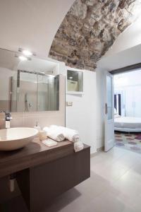 een badkamer met een wastafel en een grote spiegel bij Historic house by the lake La Renée Casa Vacanza in Predore +79 foto's