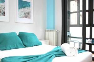 Schlafzimmer mit einem Bett in Blau und Weiß in der Unterkunft Apartamento Mas céntrico del Húmedo Desayuno in León