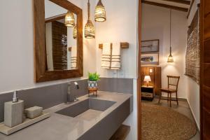 a kitchen with a sink and a mirror at Flamboyant Residence Quadrado in Trancoso +67 photos