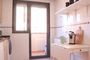a kitchen with a sliding glass door in a kitchen at Espacioso piso leon vut227 in León +15 photos