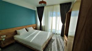 una camera con un letto con una parete blu di Pensiunea Caluda a Mamaia Nord - Năvodari