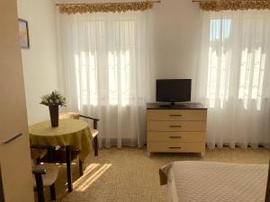 a bedroom with a tv on a dresser with a table at Villa California in Darlowko