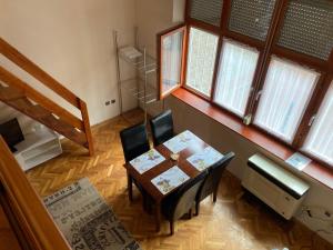 a dining room with a table and chairs and a piano at Halkoz Apartment in Debrecen