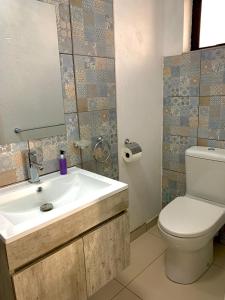 y baño con lavabo, aseo y espejo. en Thamani Guest House en Randfontein