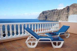 聖地亞哥德爾埃泰德的住宿－El Paraíso en Los Gigantes，俯瞰大海的阳台的椅子