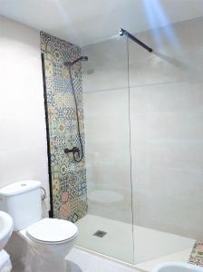 y baño con ducha de cristal y aseo. en Acogedor apartamento VALLE DEL JERTE, en Piornal