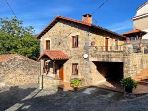 a large stone building with a balcony on it at Apartamentos rurales La Casa Vieja De Alceda in Alceda