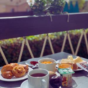 een tafel met borden en kopjes koffie bij La Maison Du Belvedere in Saint-Cyprien