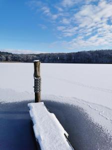 eine Stange im Schnee neben einem Wasserkörper in der Unterkunft Gasthof & Hotel Heidekrug in Plau am See